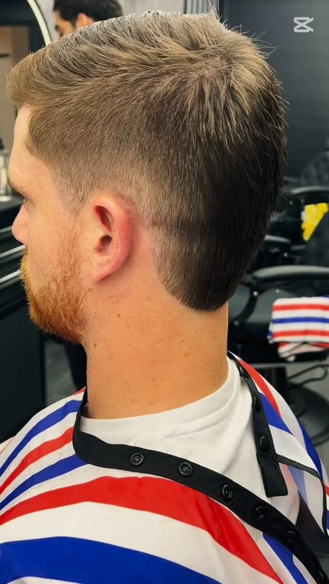 Textured quiff with red beard taper, barber-stripe cape