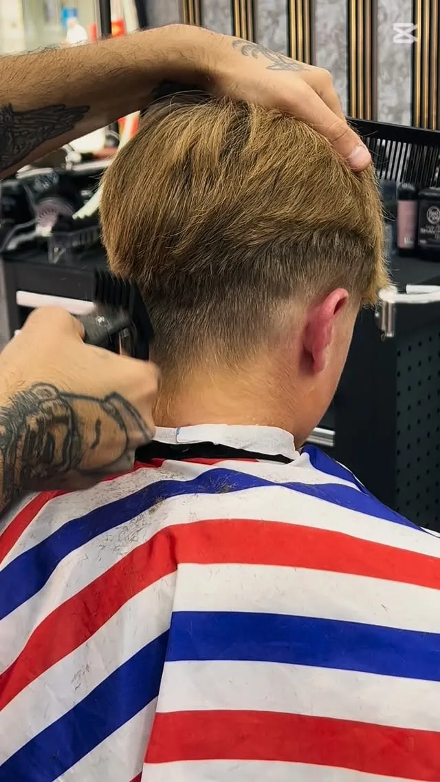Barber's tattooed hands at work — craft detail