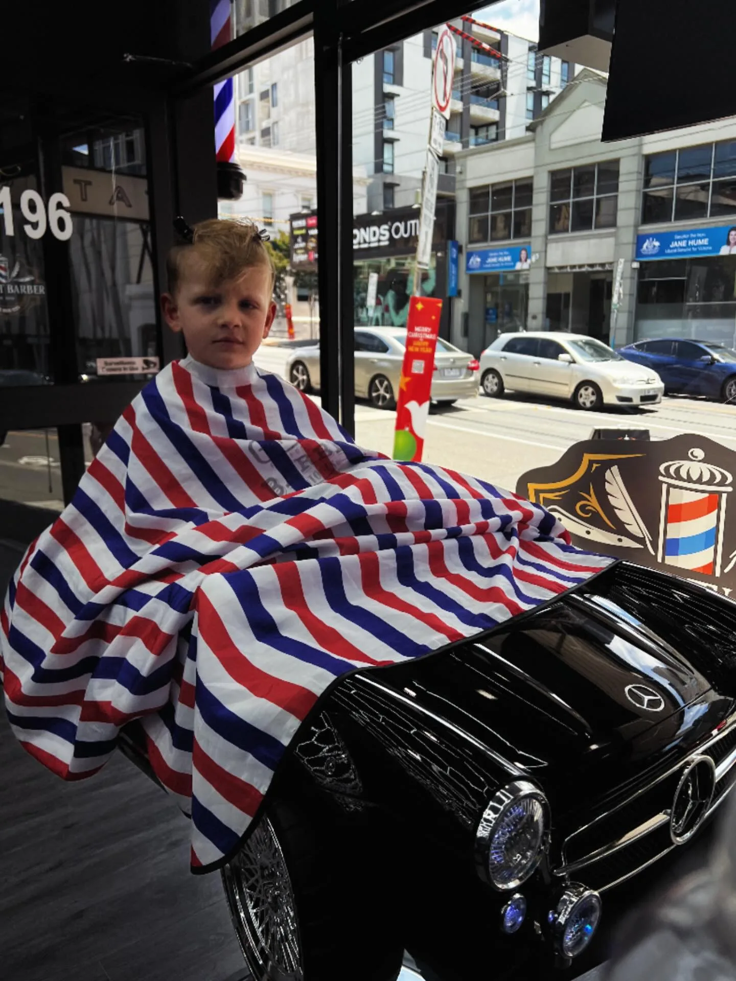Kids' cut — child in the Mercedes barber chair at 196 Bridge Road